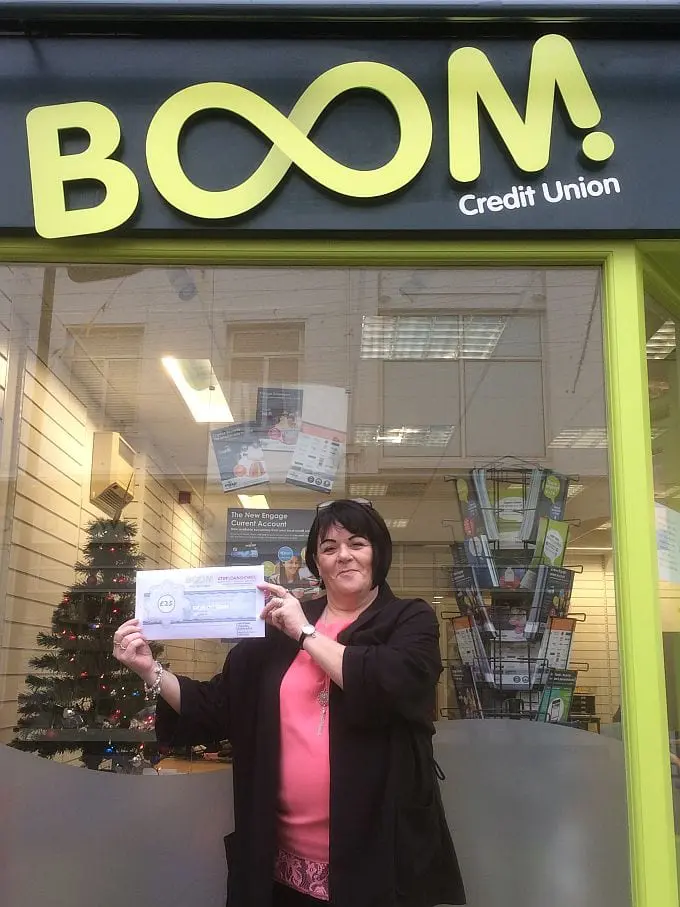 Jenny Attree (BOOM! Credit Union Volunteer) holding a £25 Stop Loan Sharks voucher